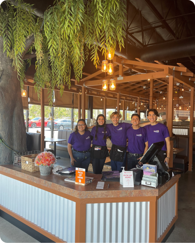 A group of people standing at a cash register.